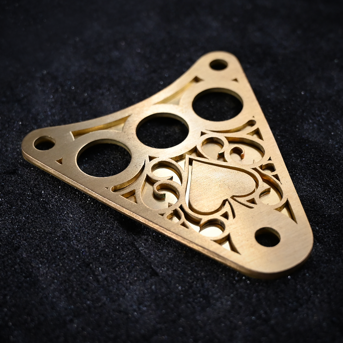Decorative Kawasaki Vulcan 800 dash plaque made out of raw brass laying in a display case.