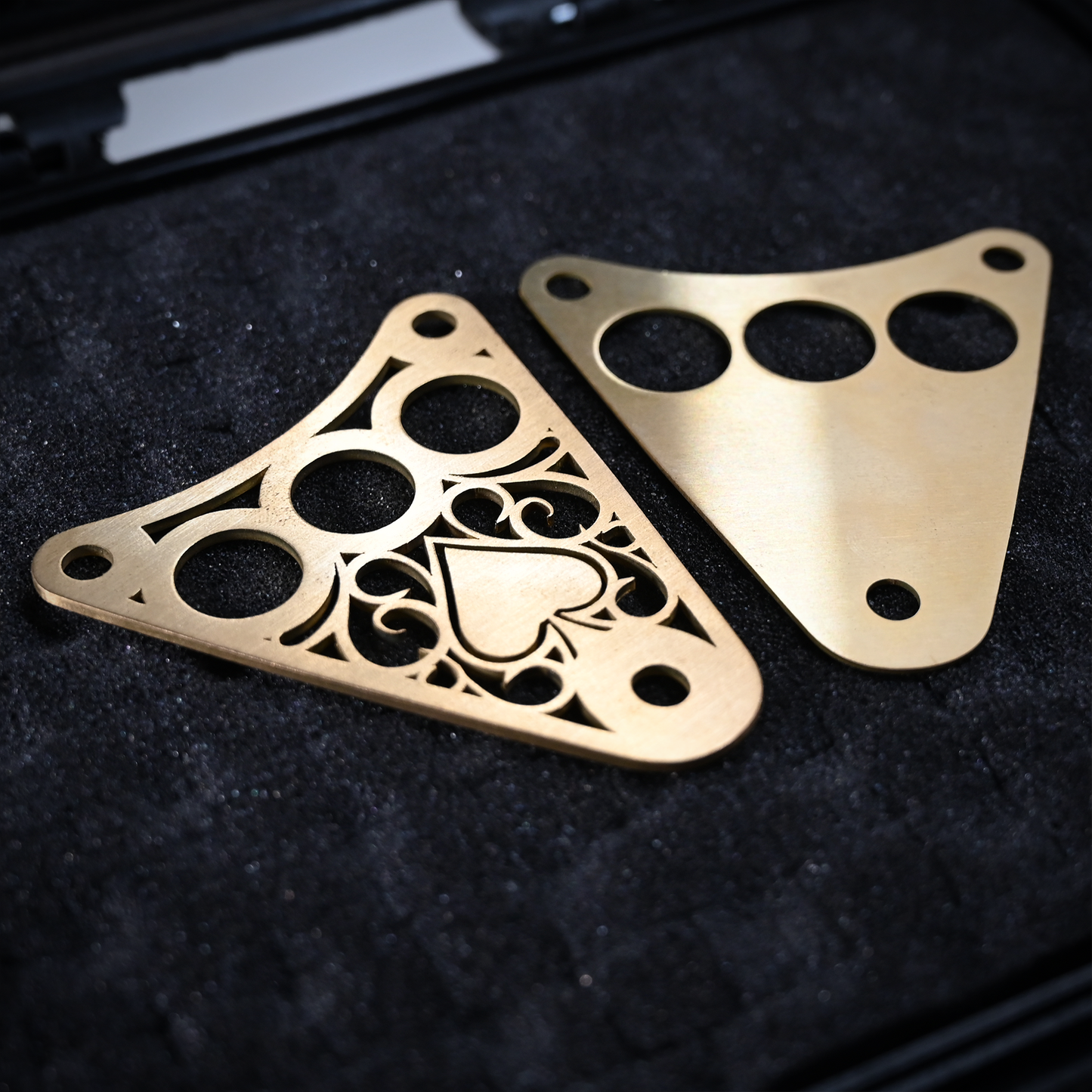 Decorative Kawasaki Vulcan 800 dash plaque made out of raw brass laying in a display case with front and back plaque separated.